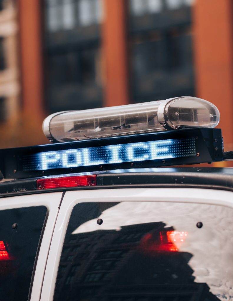 Detailed view of a police car with flashing lights in an urban environment, emphasizing safety.